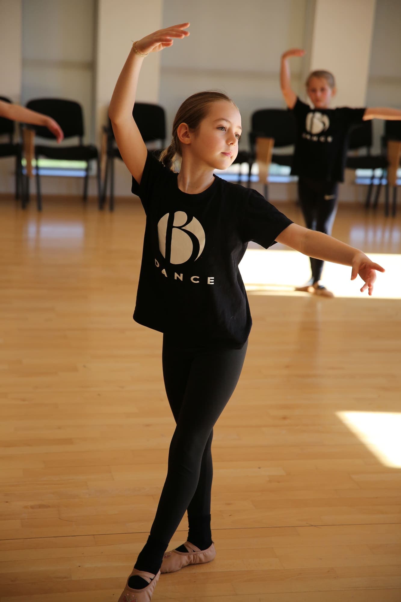 A young dancer holding a ballet pose