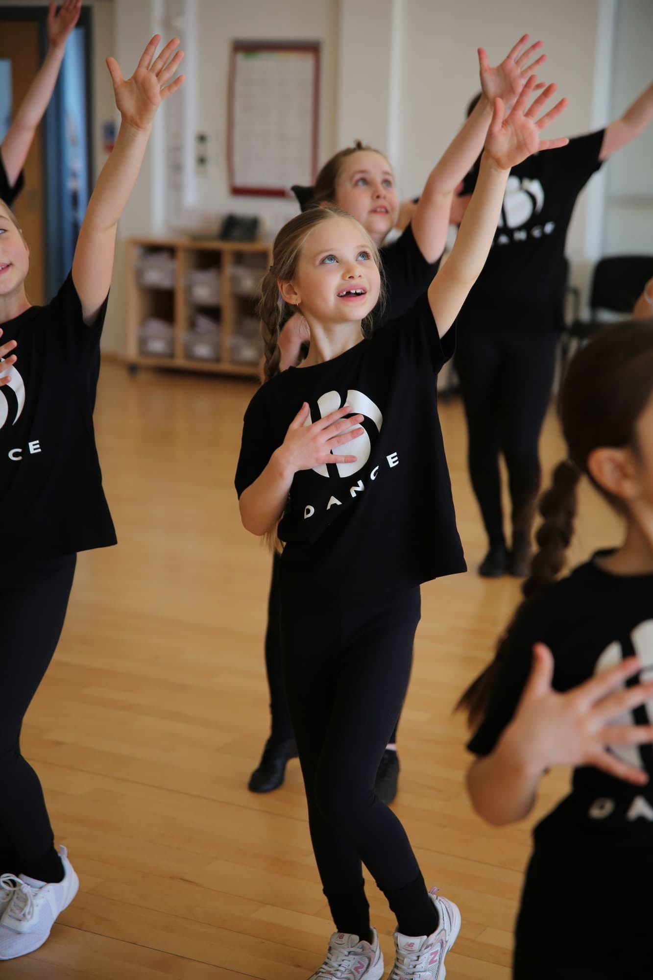 Junior dancers reaching up during a routine