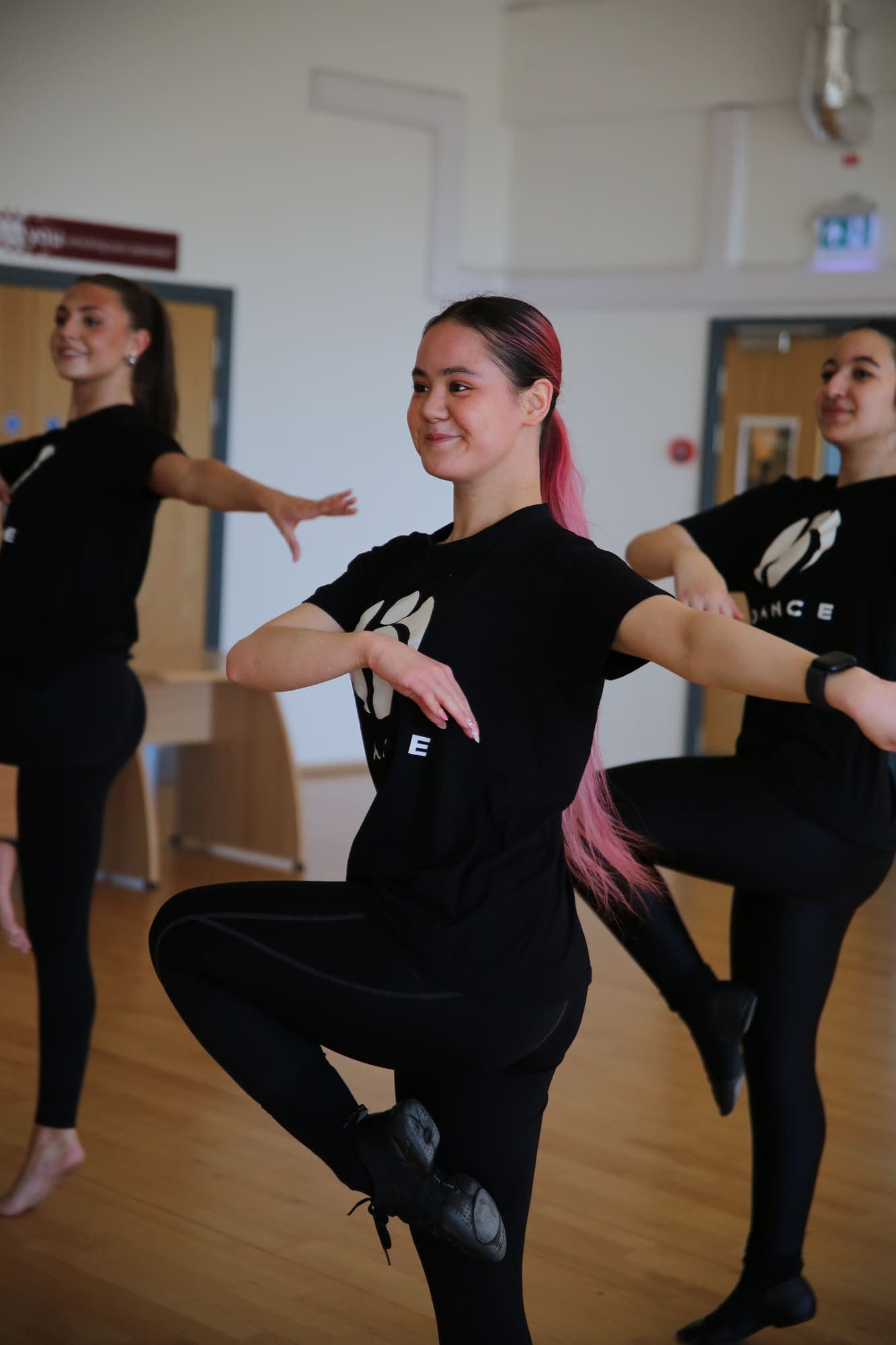 A dancer balancing on one leg during class